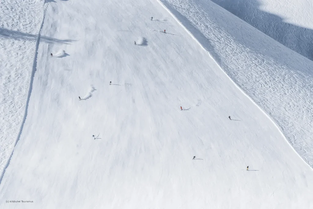 Landschaft Skigebiet Kitzbuehel Winter Skipiste C Skiers descending groomed run at Kitzbuhel