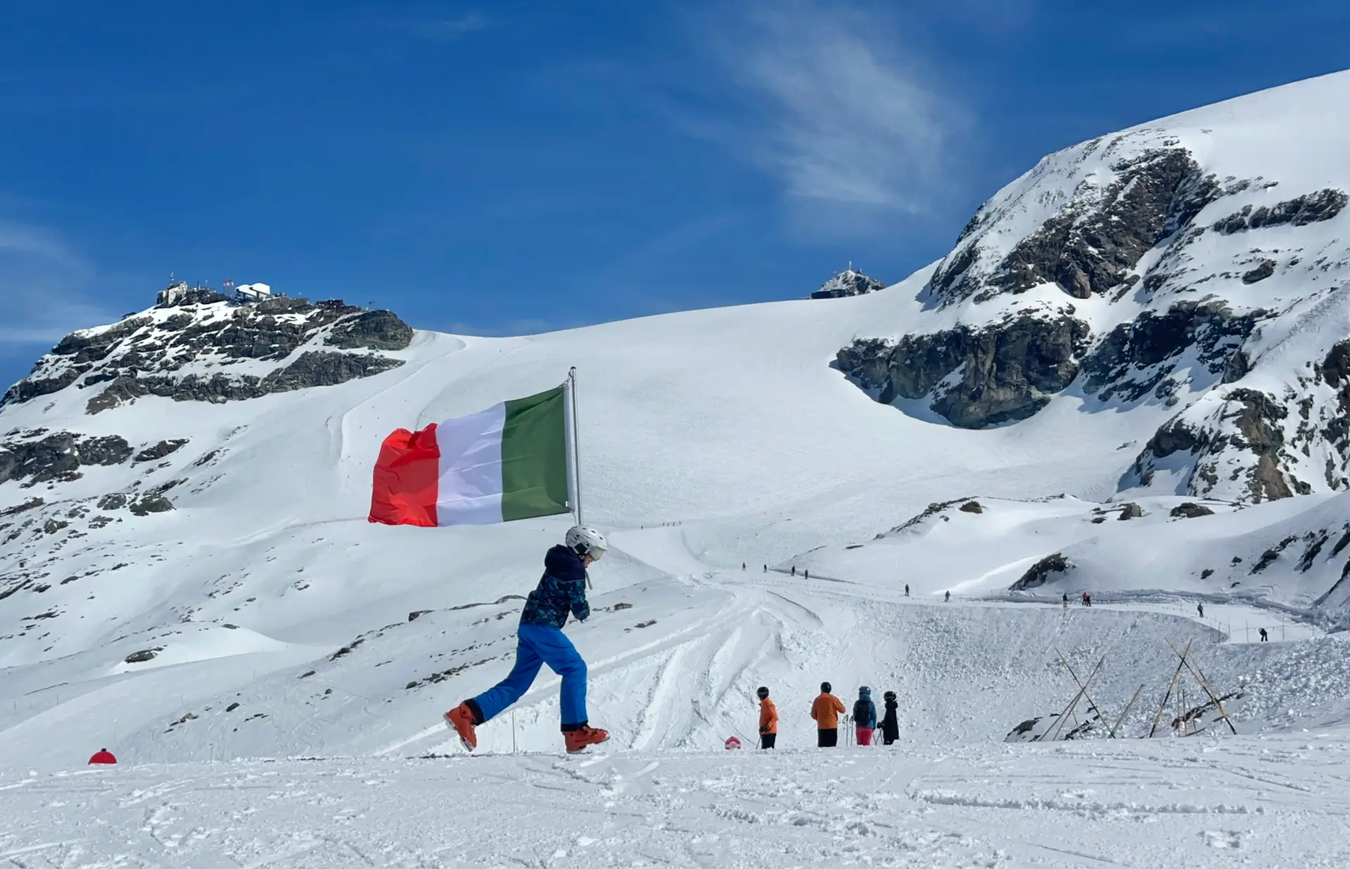 skier running across the snow with Italian flag