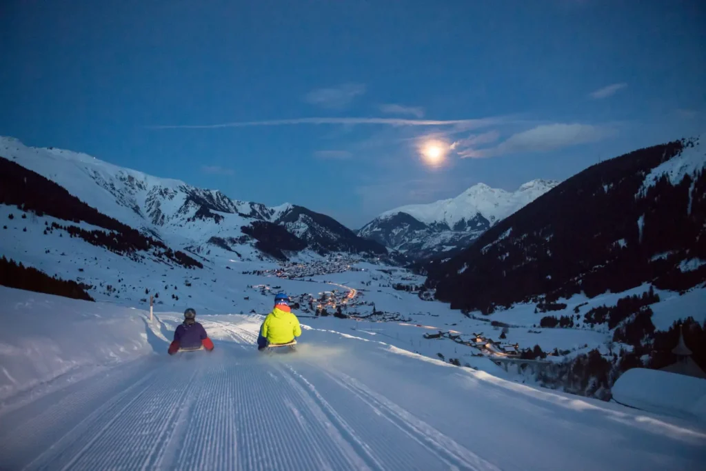 sledders in a night slide in Andermatt