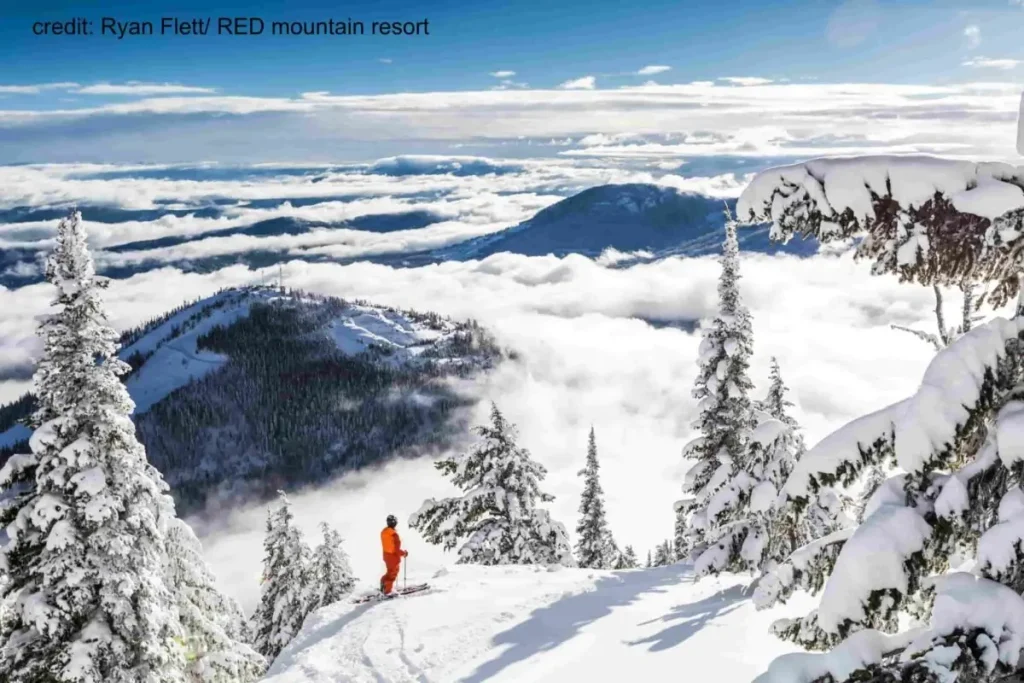 Red Mountain 3 skier looking out over a snowy, cloud topped Red Mountain ski resort