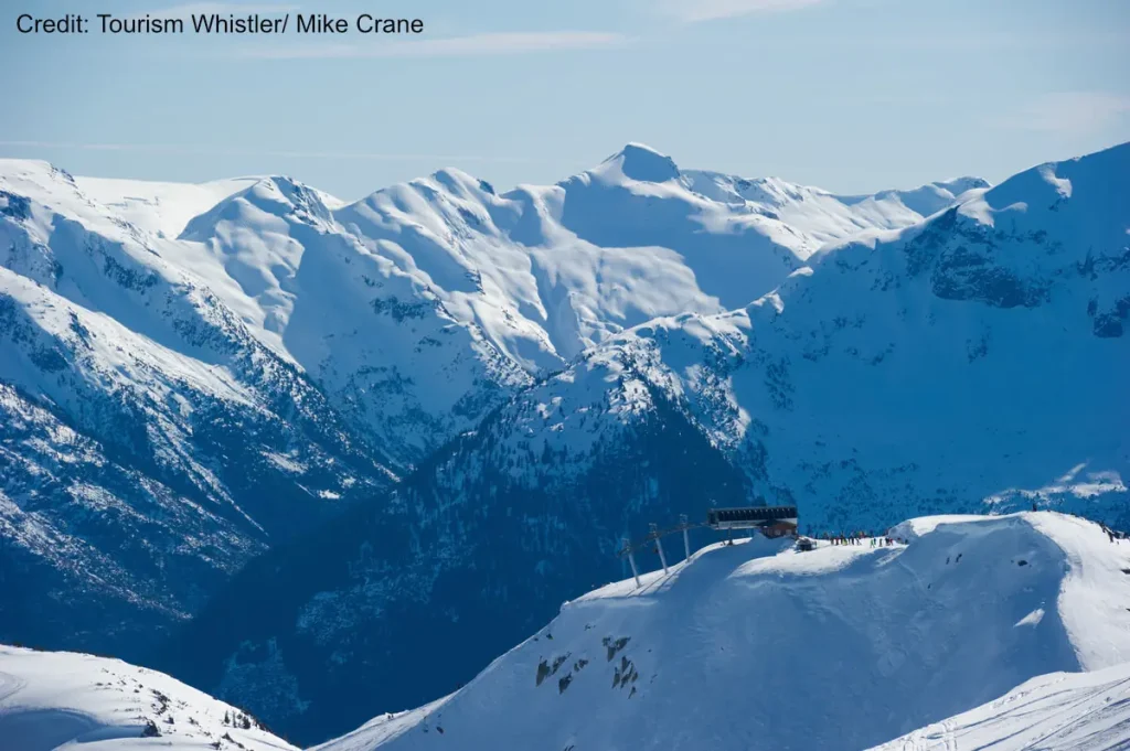 Ski Whistler 2 view of the top of a chairlift overlooking snowy peaks at Whistler