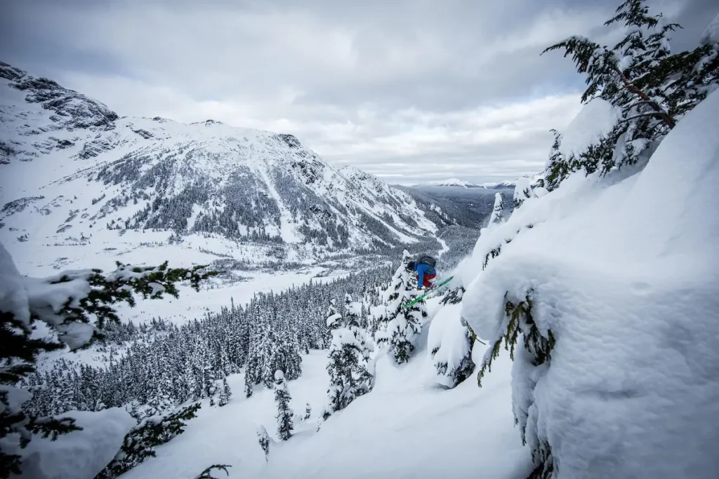 Westcoast Heli 3 skier going off big drop in Skeena Bearclaw lodge backcountry