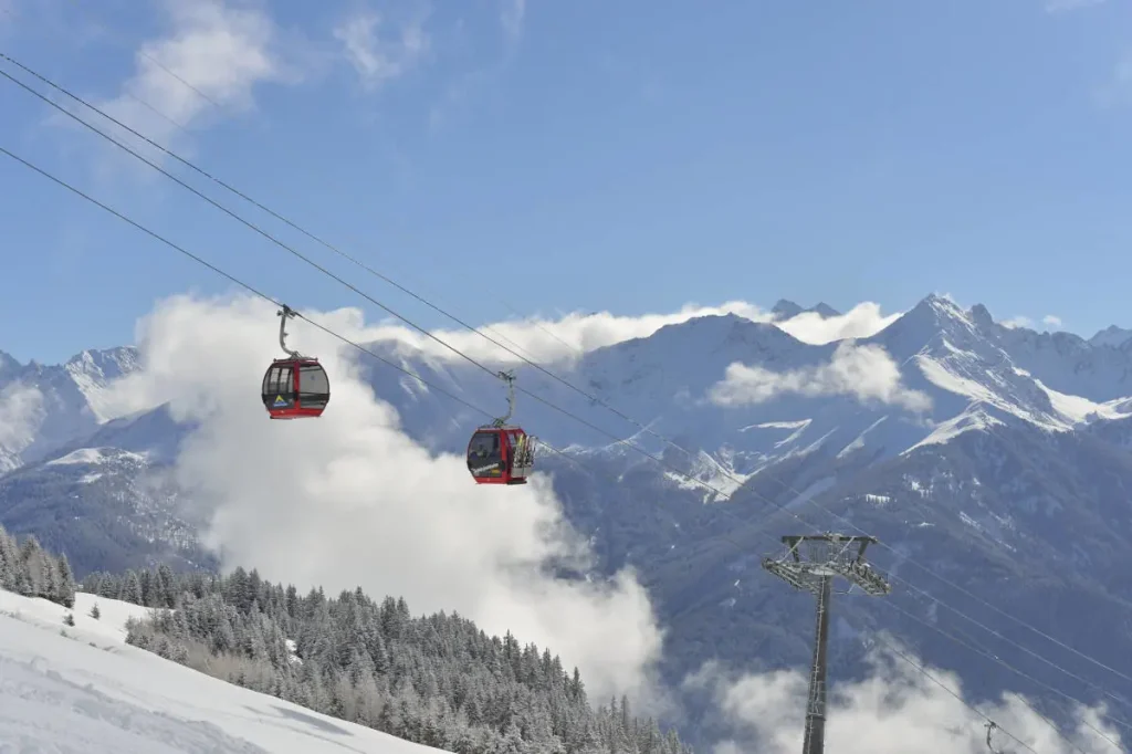 Gondolas above the clouds on a sunny day in Fiss