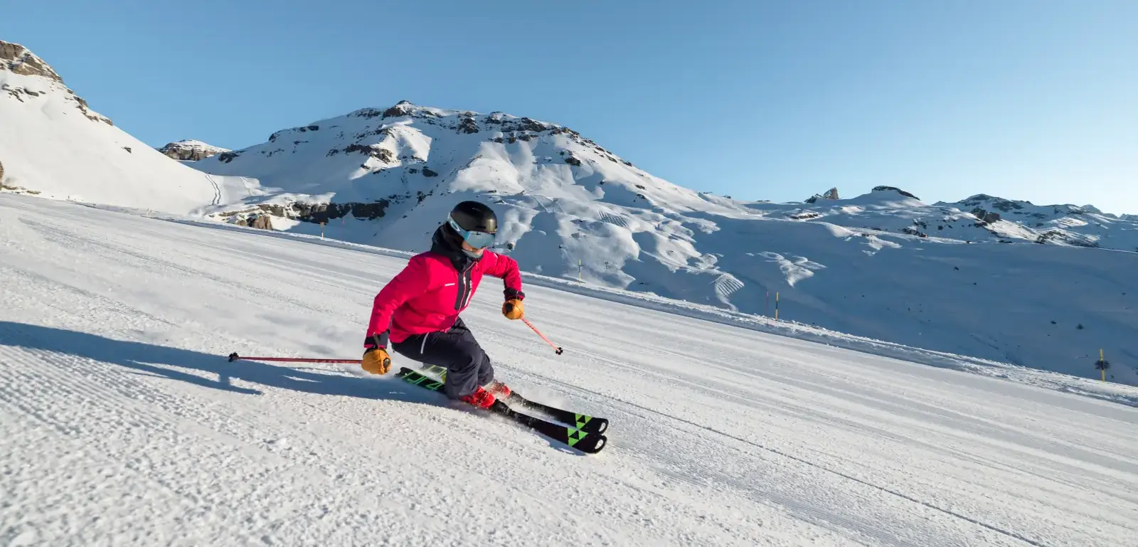 skier descending a groomed slope in Crans Montana