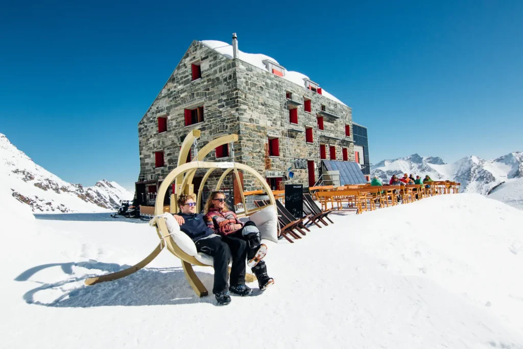 skiers relax on an outdoor swing chair