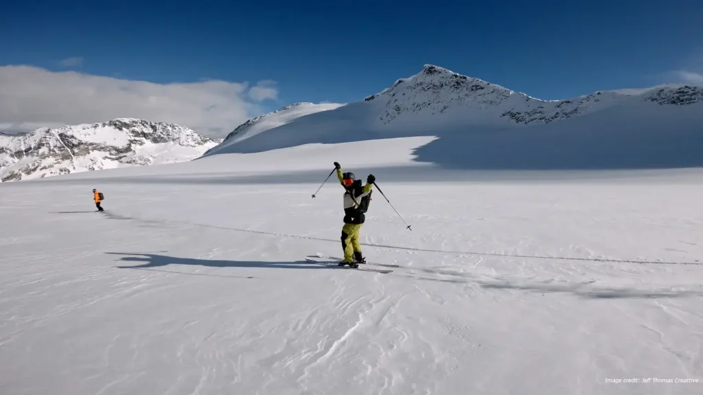 Heli skiers traversing a snowfield