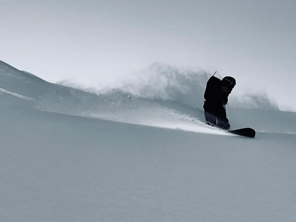 snowboarder in deep powder on a heli run in Whistler