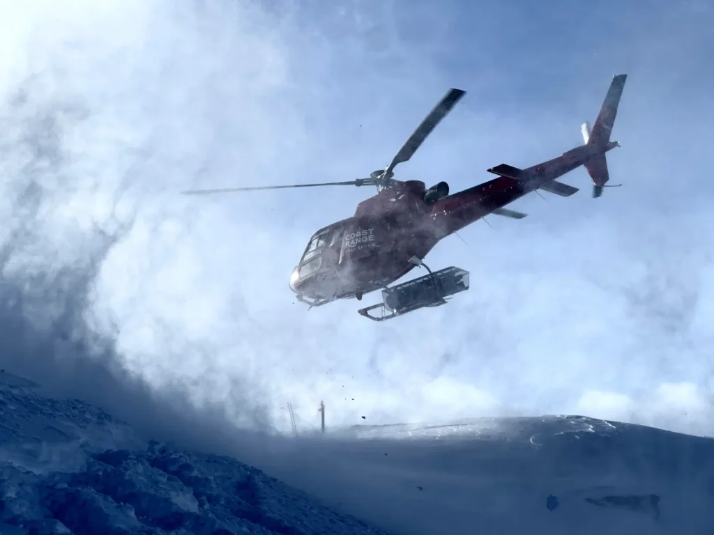 Coast Range helicopter lifting off after droping heli-skiers