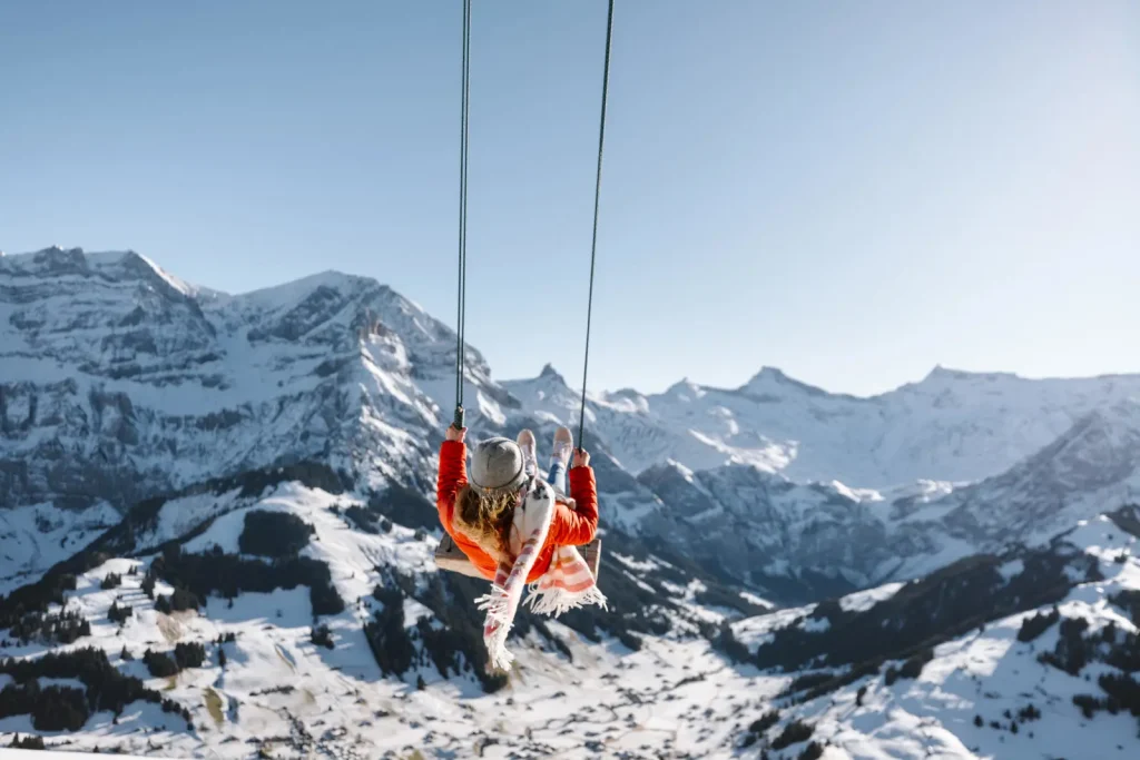 woman on a swing high above Adelboden ski resort
