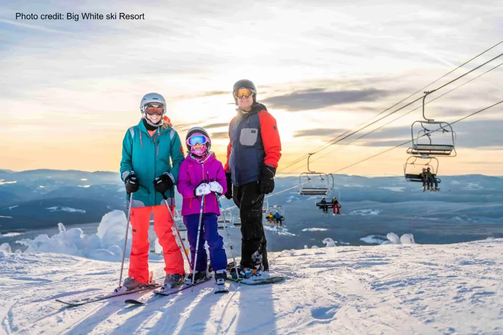 family posing atop a run at Big White Ski Resort