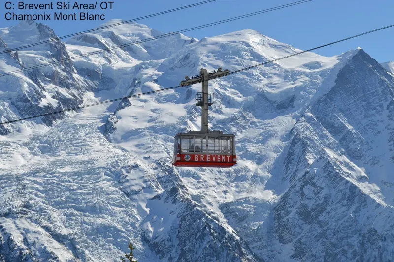 A gondola ascending against a backdrop of snowy peaks in Chamonix