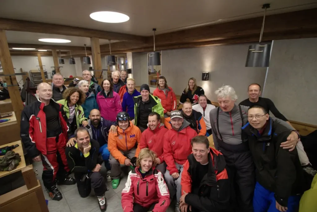 group of skiers pose for a photo inside the lodge after a day of skiing