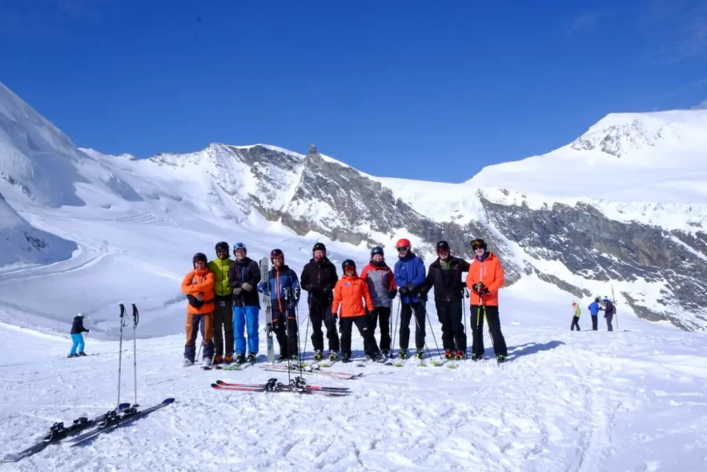 group of skiers standing atop a ski hill on a group vacation with Canadian Ski Vacations