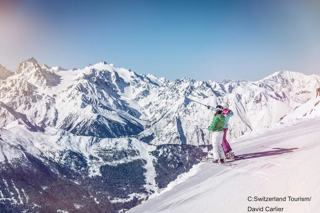 skiers standing atop a run in Verbier