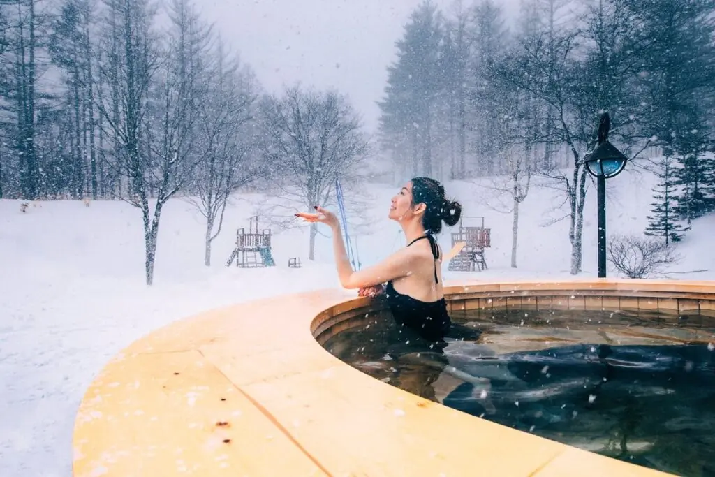 woman in hot tub on a snowy day in Sahoro, Japan