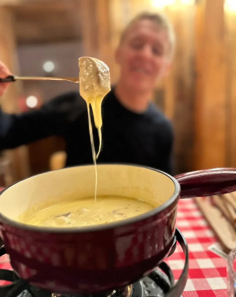 Andermatt2025-4 woman trying the fondue in Andermatt, Switzerland