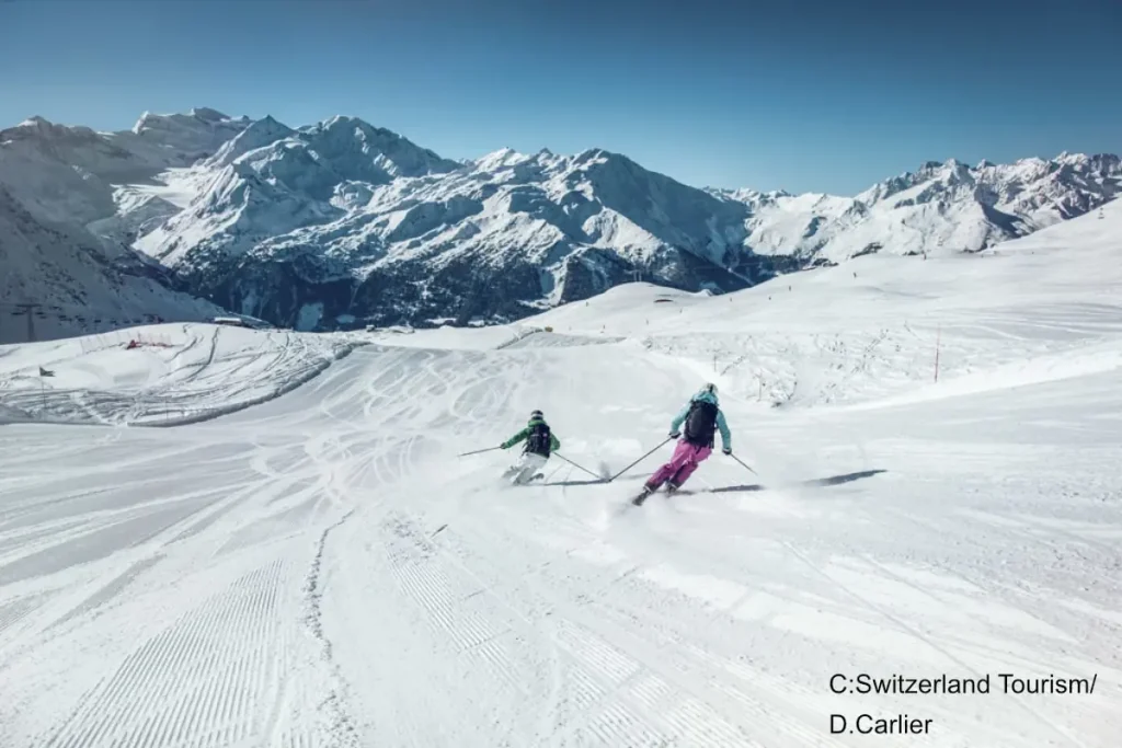 2 skiers on a groomed run in Verbier