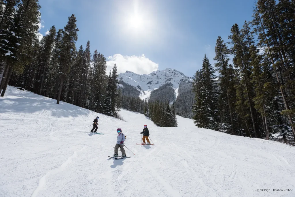 family skiing a groomed run in Banff, Sunshine Village