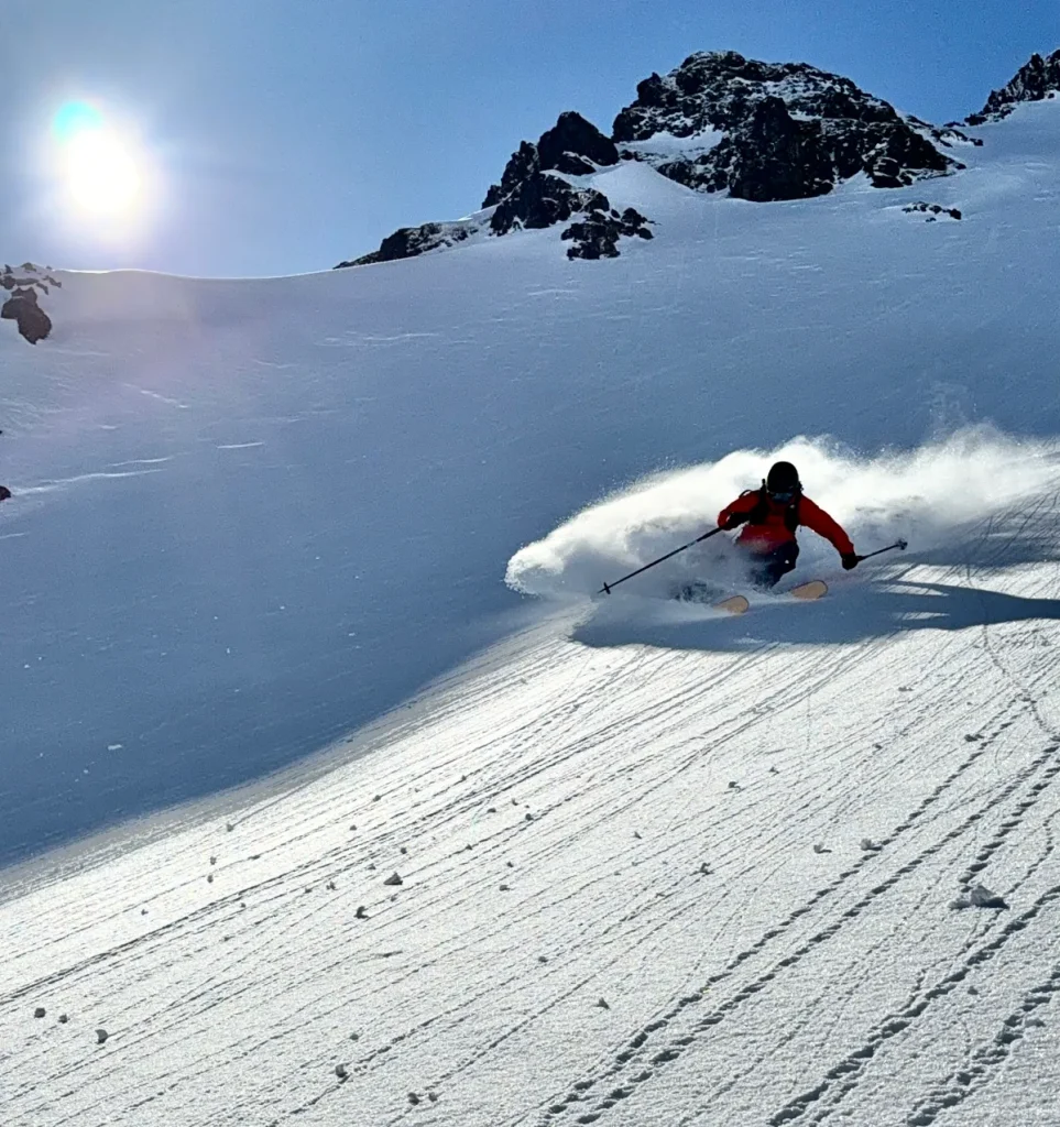 skier in steep powder on a sunny day in Iceland