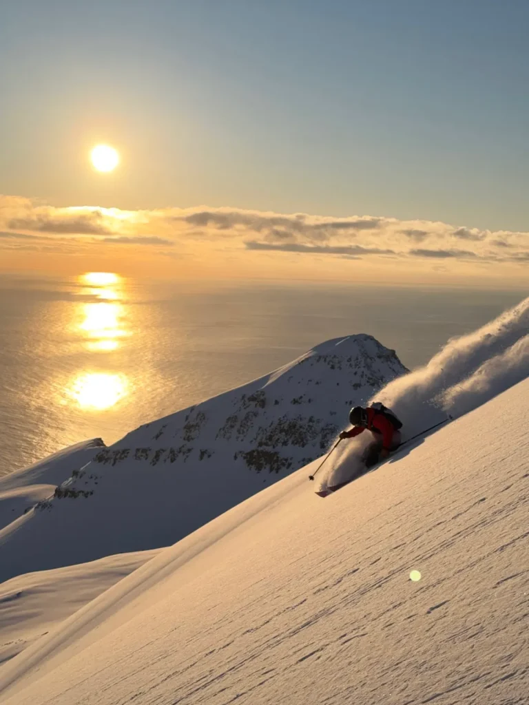 skiing steep powder against a setting sun in Iceland