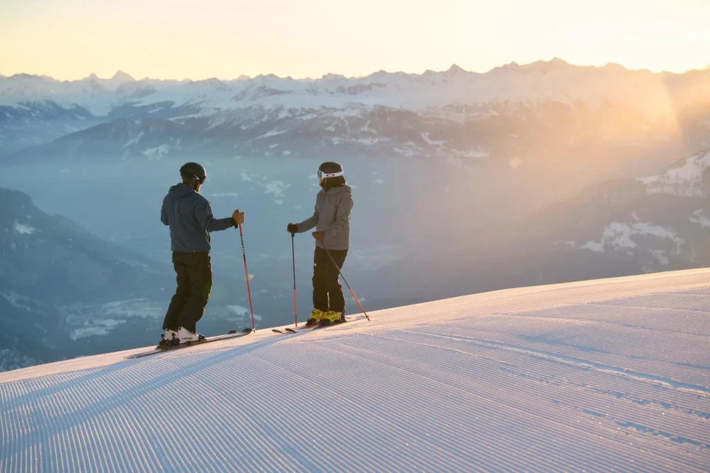 2 skiers atop Flims/Laax at sunrise